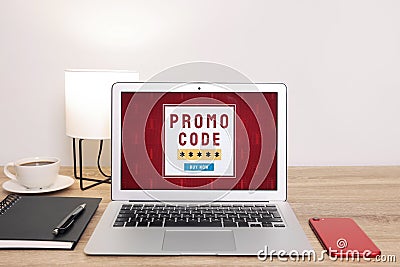 Laptop with activated promo code on wooden table indoors Stock Photo