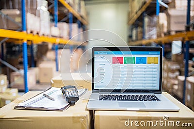 Laptop and barcode scanner on boxes in a warehouse. Stock Photo