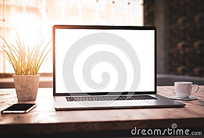 Laptop with blank screen mockup template on table in industrial old factory loft interior Stock Photo