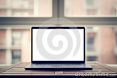 Laptop with blank screen on table in modern loft Stock Photo