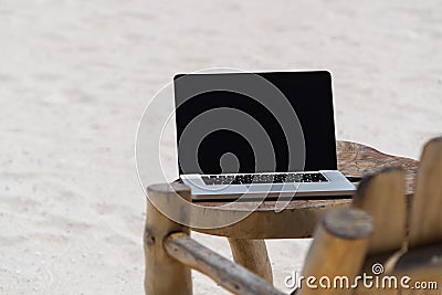 Laptop blank screen on wooden desk with beach. relax concept. Stock Photo