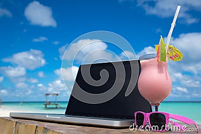 Laptop blank screen on wooden desk with beach. relax concept. Stock Photo