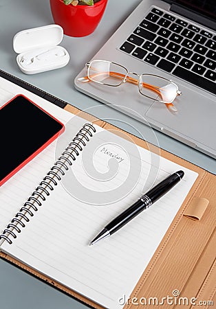 Laptop, cell phone and opened agenda on a grey desk close up Stock Photo