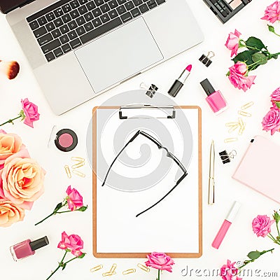 Laptop, clipboard, glasses, roses flowers, cosmetics and accessories on white background. Flat lay. Top view. Freelancer compositi Stock Photo