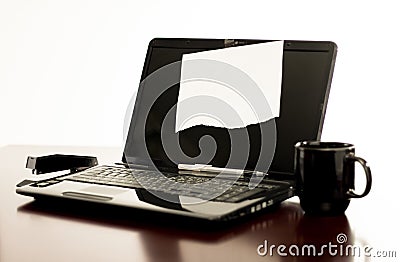 Laptop computer on desk with blank paper taped to the display screen Stock Photo