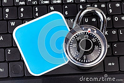 Laptop computer keyboard, a number code combination padlock and a blank empty square label, cybersecurity, account security Stock Photo