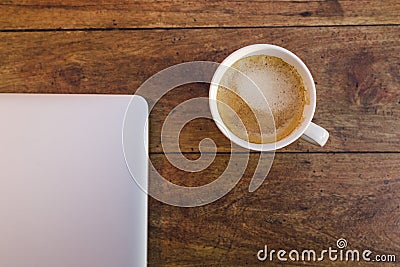 A laptop and a cup of coffee over a wood table Stock Photo