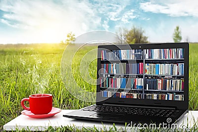 Laptop and cup of hot coffee on the background picturesque nature, outdoor office. E-book library concept. Internet books store. Stock Photo