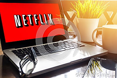 Laptop displaying Netflix word on wooden table Editorial Stock Photo