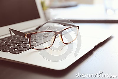 Laptop with eyeglasses on table prepared for business meeting in conference hall Stock Photo