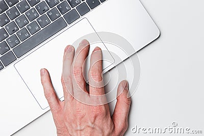 Laptop and hand, top view. The user works on a modern laptop using a trackpad. Modern technology Stock Photo