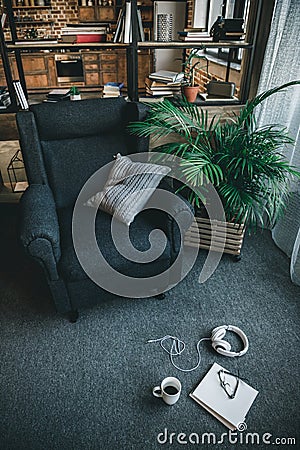 Laptop with headphones, eyeglasses and cup of coffee on carpet in empty room Stock Photo