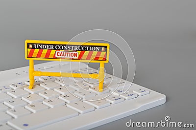Laptop keyboard and under construction sign. Website maintenance, programming, repair, coding and under maintenance concept Stock Photo