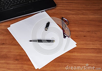 Laptop keyboard, white paper, ink pen and glasses on a wooden table. Empty space for your copy text Stock Photo