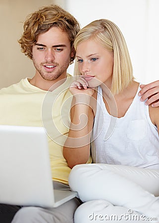 Laptop, love and couple relax in a house streaming movies, video or film, show or social media together. Tech, search Stock Photo
