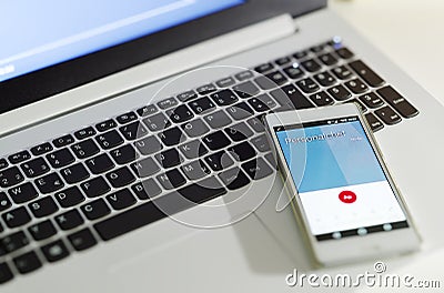 Laptop with mobile phone and call of the personnel manager to symbolize a warning or termination of the text in the mobile phone i Stock Photo