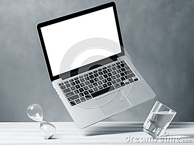 Laptop mockup, computer with blank screen flying under the table. Editorial Stock Photo