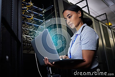 Laptop, network and data center with a black woman it support engineer working in a dark server room. Computer Stock Photo