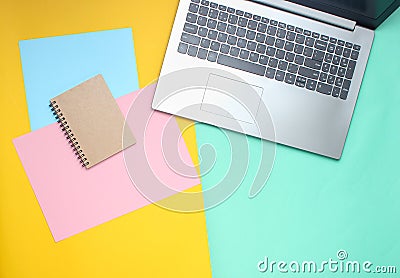 Laptop, notebook on a colored pastel background, modern workspace, minimalism, flat lay style, top view. Stock Photo