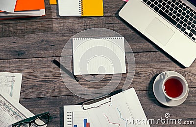 Laptop, notepad, glasses and tea cup on office wooden table Stock Photo