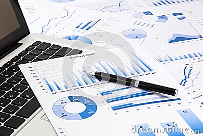 Laptop and pen with blue business charts, graphs, statistic and Stock Photo