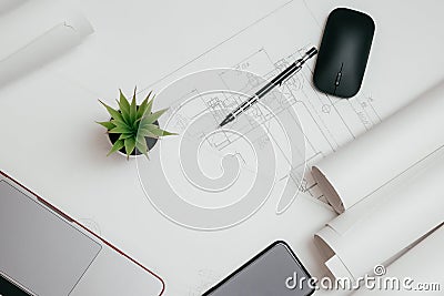 Laptop, phone and rolls of drawings on the Desk in engineering. architectural background with rolls of technical Stock Photo