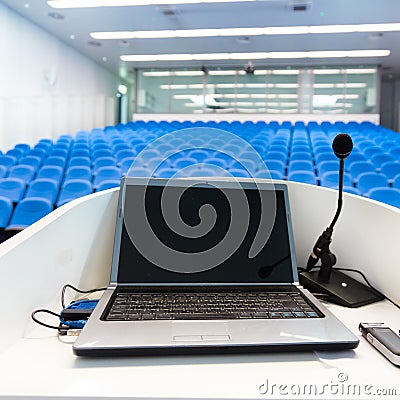 Laptop on the rostrum in conference hall. Stock Photo