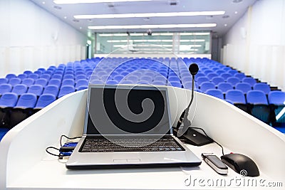 Laptop on the rostrum in conference hall. Stock Photo