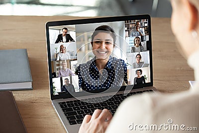 Laptop screen over woman shoulder view during group online communication Stock Photo