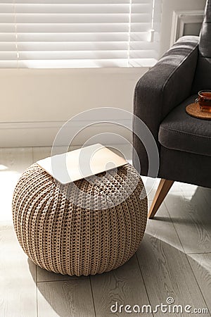 Laptop on stylish comfortable pouf in room. Home design Stock Photo