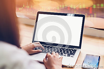 Laptop on table in office room on stock exchange trading graph for background, for graphics display montage. Stock Photo