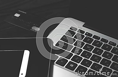 Laptop, Tablet, smartphone and credit card lying on a black background Editorial Stock Photo