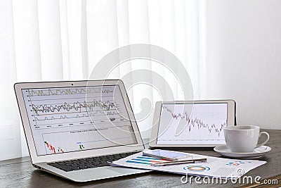 Laptop, tablet ,smartphone with financial documents on wooden table Stock Photo