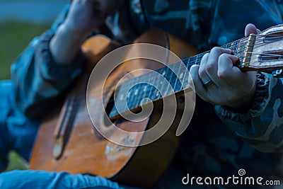 A large acoustic old guitar in the hands Stock Photo