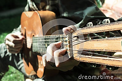A large acoustic old guitar in the hands Stock Photo
