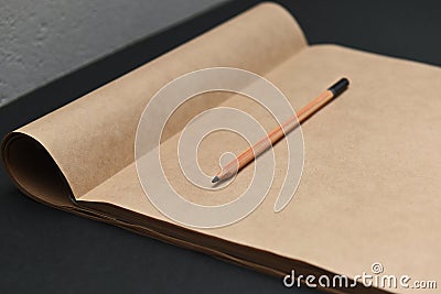 Pencil and opened album made of dark paper for sketching Stock Photo