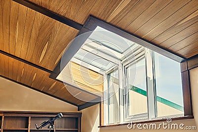 Large attic window with wooden ceiling. Stargazing telescope Stock Photo