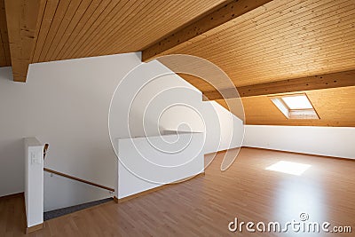 Large attic with wooden floors and exposed beams Stock Photo