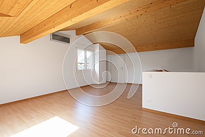 Large attic with wooden floors and exposed beams Stock Photo