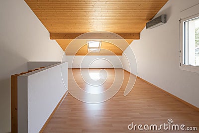 Large attic with wooden floors and exposed beams Stock Photo