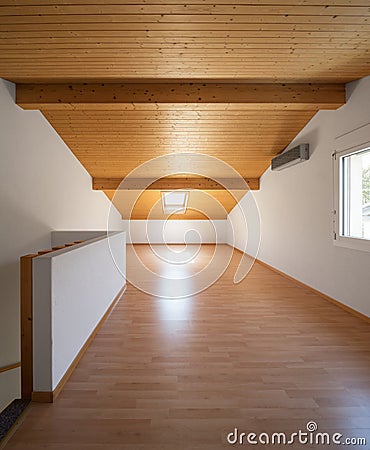 Large attic with wooden floors and exposed beams Stock Photo