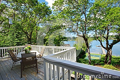 Large balcony home exterior with table and chairs, lake view. Stock Photo