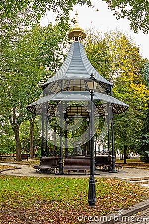 Large beautiful metal gazebo with benches in a city garden or park Stock Photo