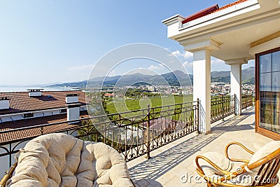 Large beautiful rich spacious veranda in the cottage with views of the mountains and the sea. Stock Photo