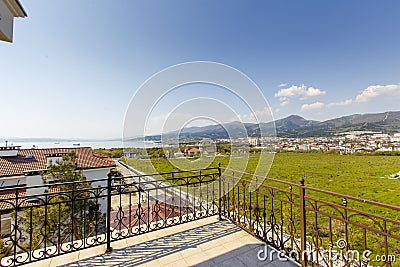 Large beautiful rich spacious veranda in the cottage with views of the mountains and the sea. Veranda with beautiful white tiles. Stock Photo