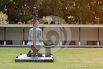 A large bell is set in the middle of the lawn in the temple Editorial Stock Photo