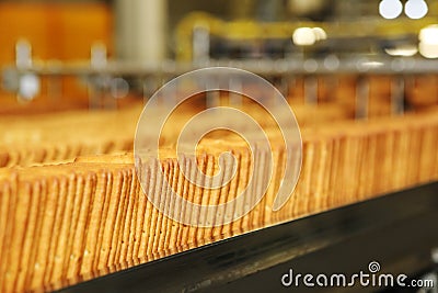 Large biscuit factory. A line of biscuits in a large factory. Packing crackers on the machine. Innovative production. Stock Photo