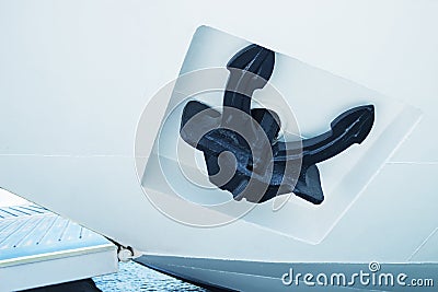 A large black anchor on a white boat. Stock Photo