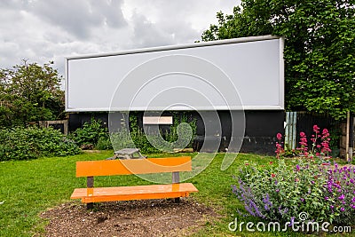 A large blank empty billboard on side of the road with bench in Stock Photo