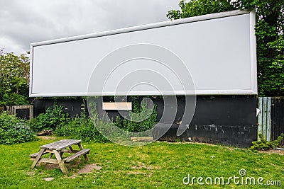 A large blank empty billboard on side of the road with bench in Stock Photo